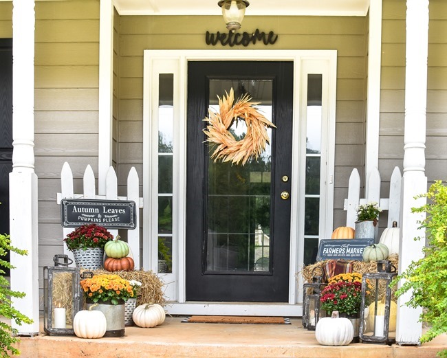 Farmhouse fall front porch with lots of mums, hay and pumpkins-21